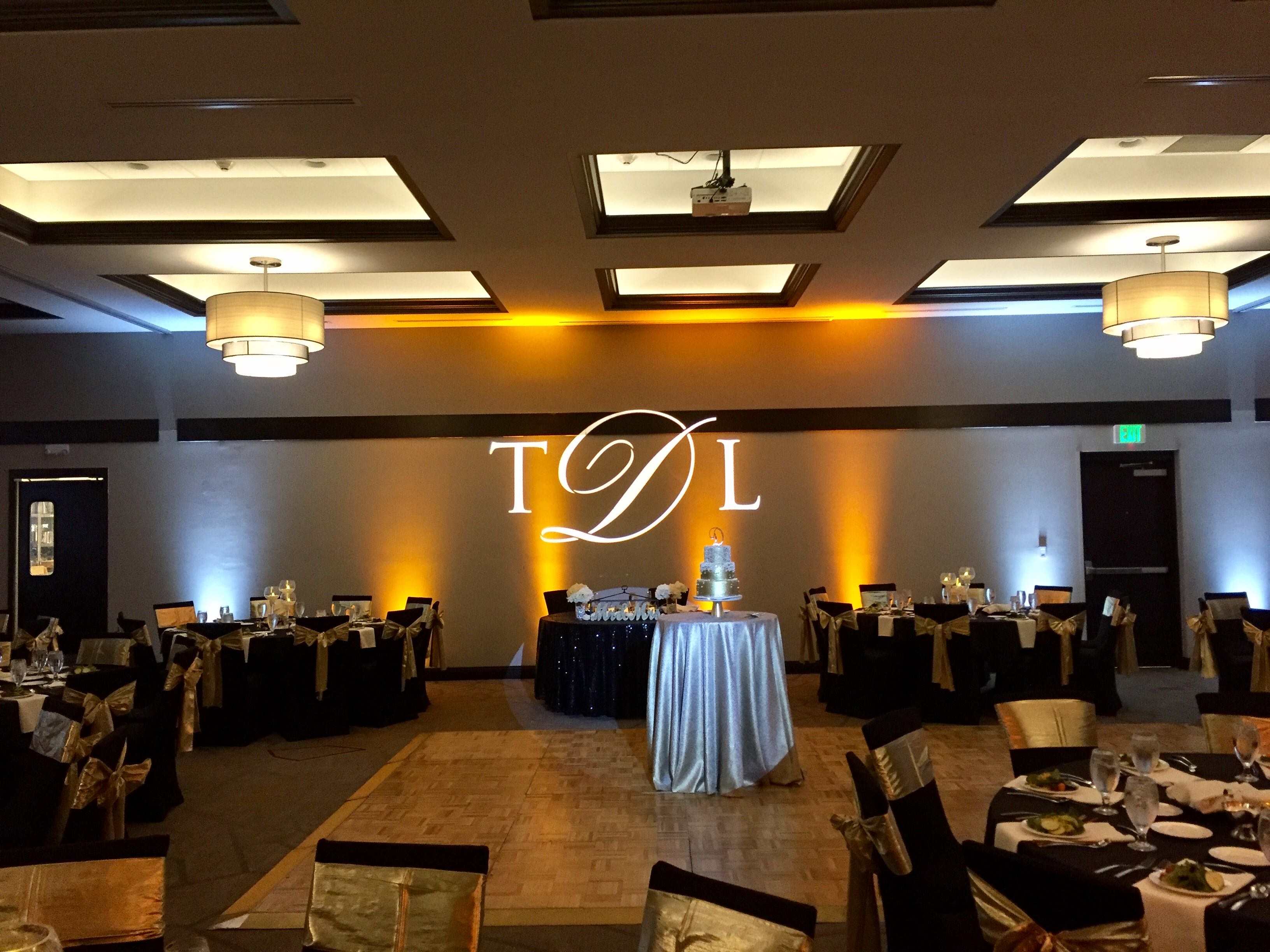 Elegant ballroom with TDL monogram projection and amber uplighting