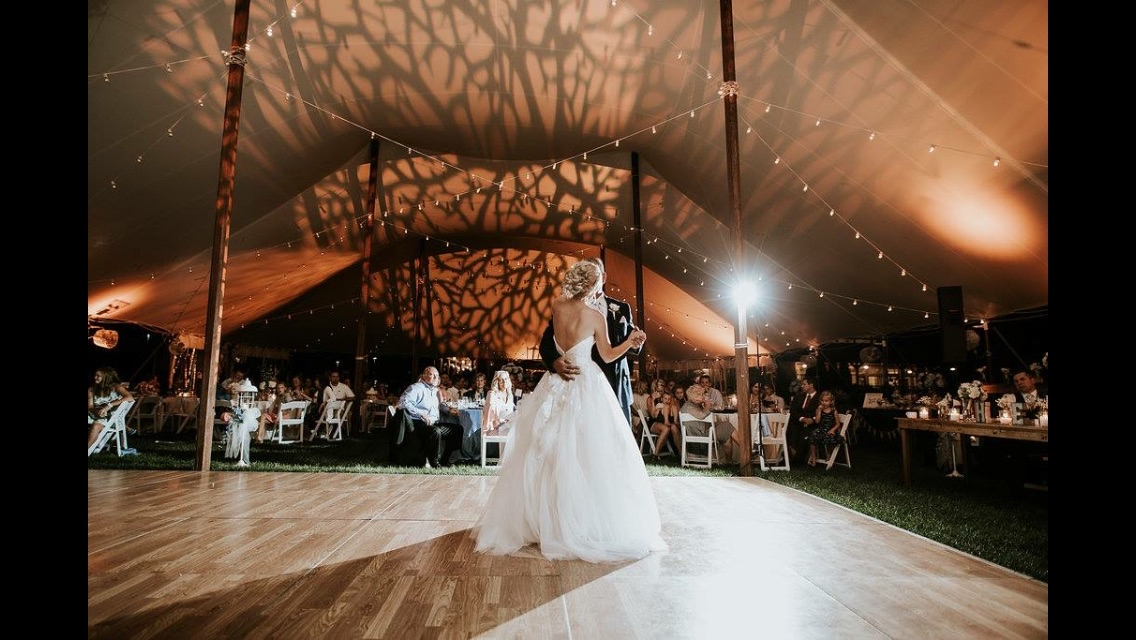 Outdoor tent wedding with dramatic tree shadow projections and string lights