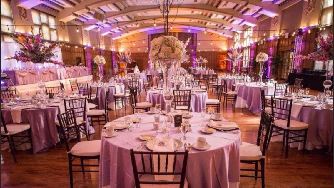 Sophisticated ballroom with purple uplighting and elegant table settings